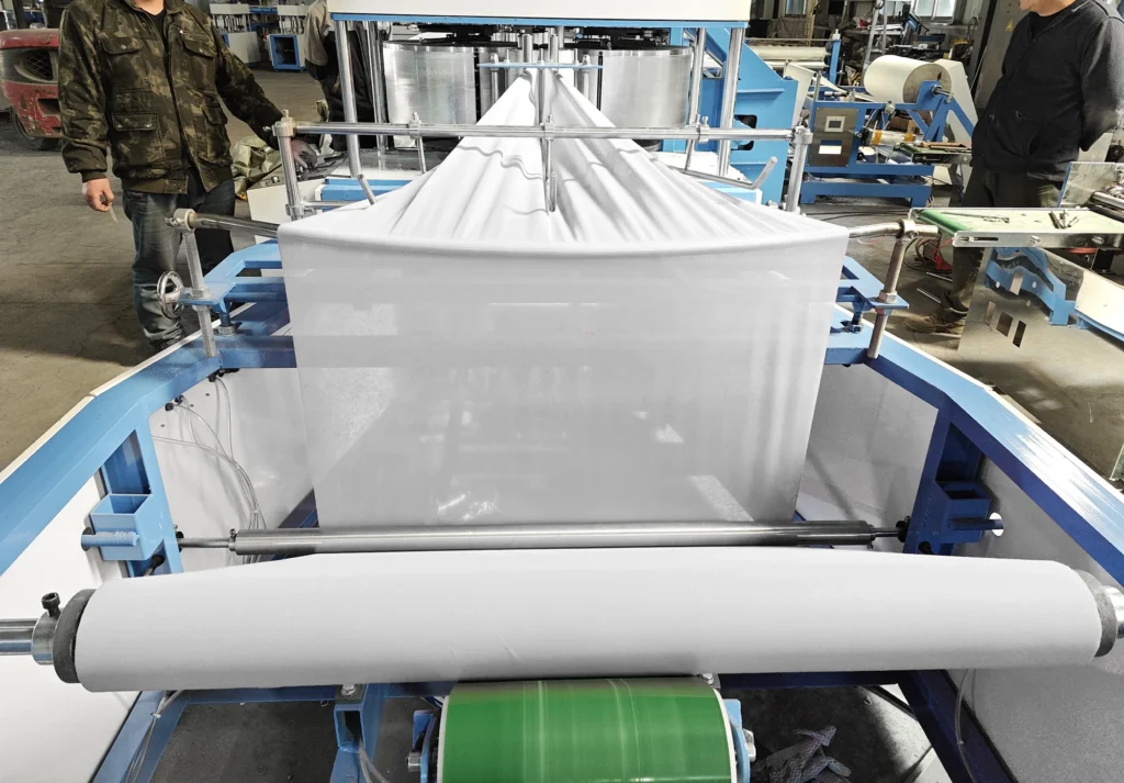 Nonwoven fabric folding machine in operation, fan-folding the web along the width direction.