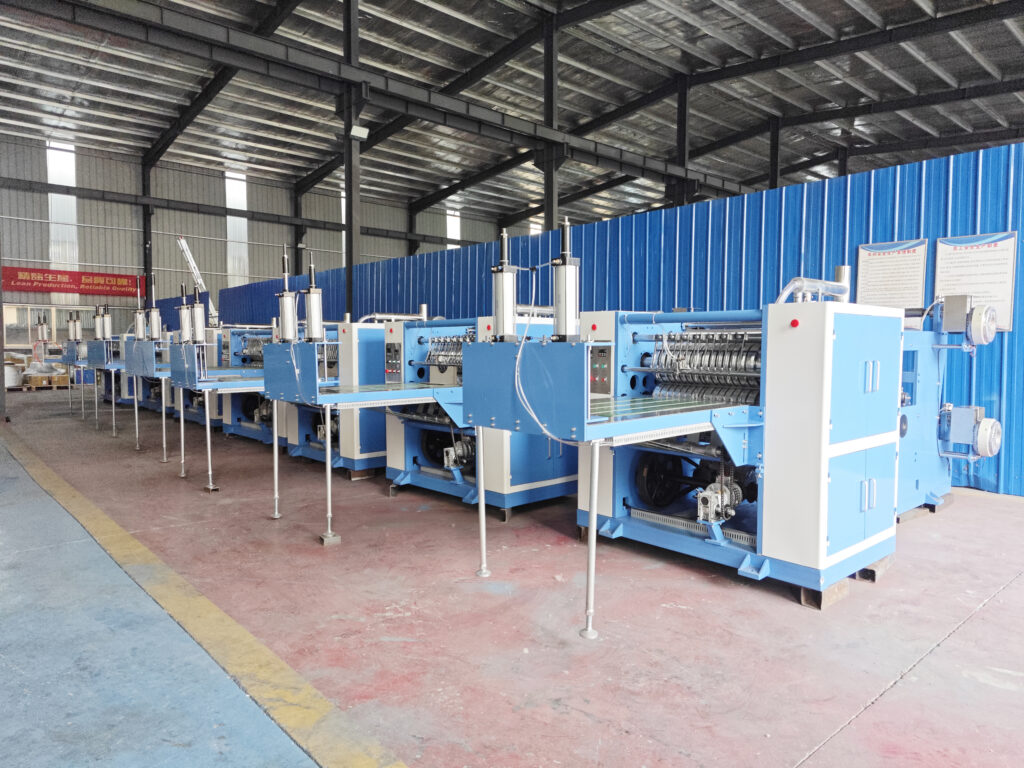 Multiple pop-up aluminum foil folding machines lined up in the workshop and ready for shipment