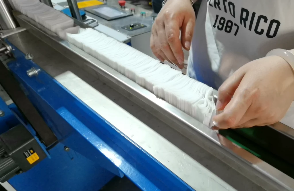 Z-folded gauze output stacking on the conveyor discharge