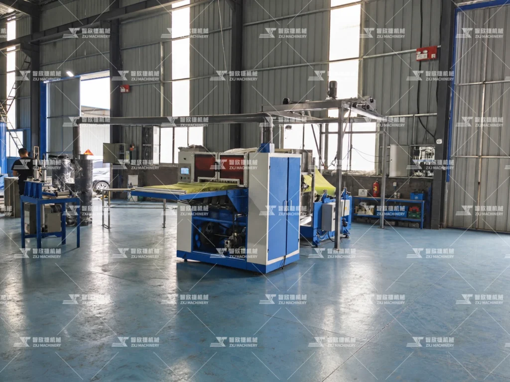 Pop-up oil-absorbing paper folding machine installed in our production workshop, showing the complete automated folding line.