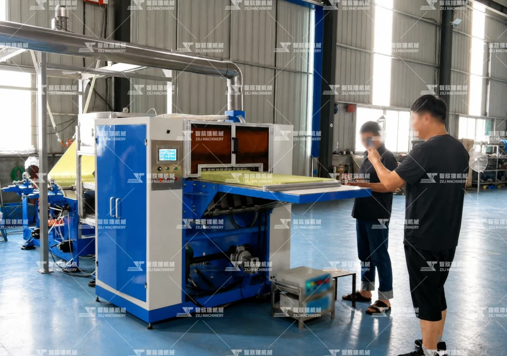 Pop-up oil-absorbing paper folding machine operating in a production workshop with two workers inspecting the finished paper sheets