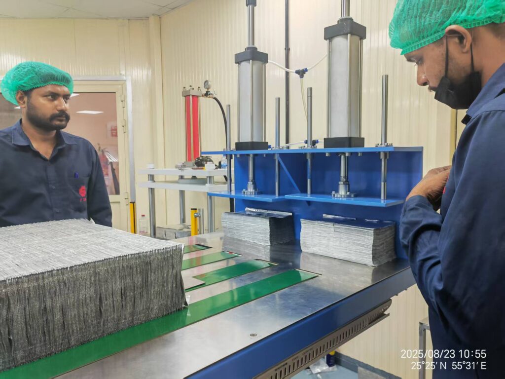 Engineers conducting on-site installation and commissioning of a pop-up aluminum foil folding machine at an overseas customer’s factory-zxj machinery
