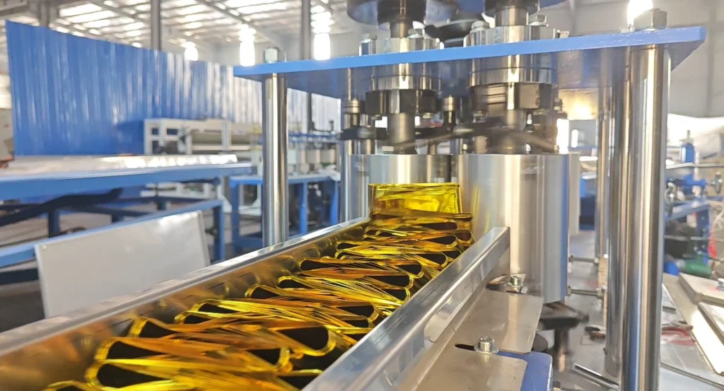 Detailed view of ZXJ Emergency Blanket Folding Machine, showing the folding and perforation process, with finished blankets being output on the conveyor.